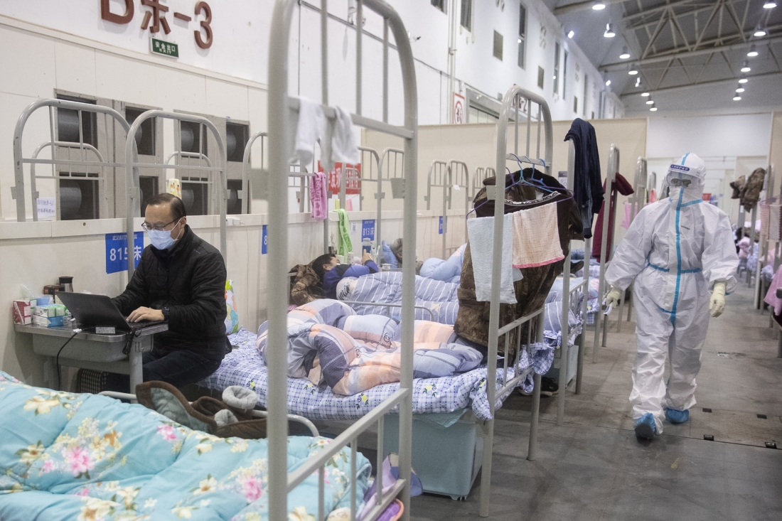 Vào ngày 17/2/2020, một bệnh nhân có triệu chứng nhẹ của virus Corona Vũ Hán sử dụng máy tính xách tay tại một trung tâm triển lãm - nơi được chuyển đổi thành một bệnh viện dã chiến ở Vũ Hán thuộc tỉnh Hồ Bắc, Trung Quốc. (Ảnh của STR / AFP qua Getty Images)