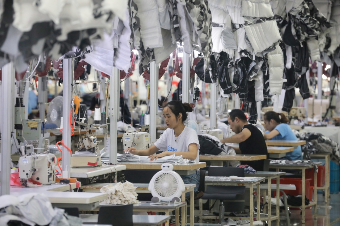 Các nhân viên sản xuất áo khoác tại một nhà máy cho công ty quần áo Trung Quốc Bosideng ở Nam Thông thuộc tỉnh Giang Tô phía đông Trung Quốc vào ngày 24 tháng 9 năm 2019 (Ảnh: STR / AFP / Getty Images)