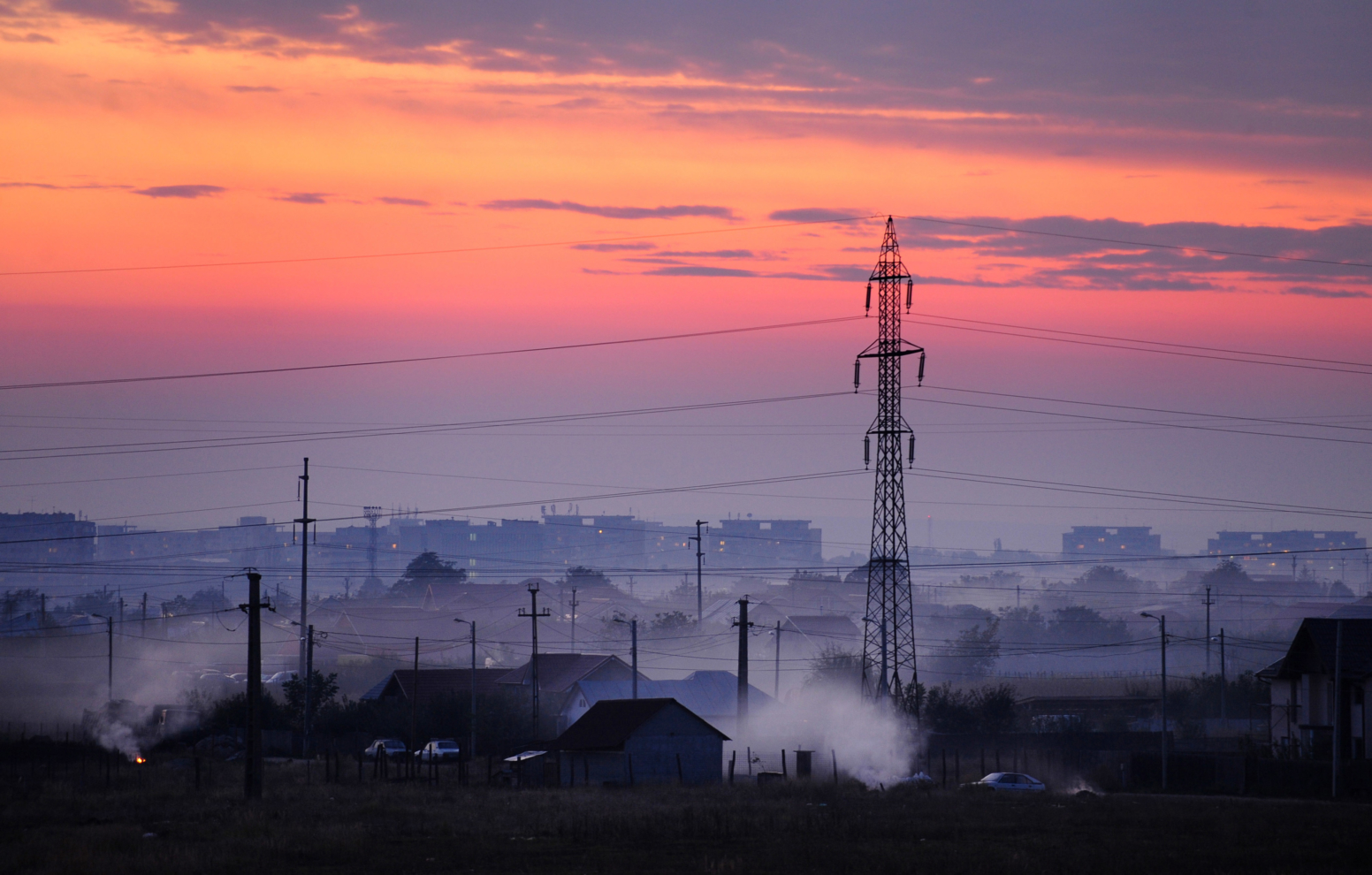 Electrical powerlines are seen abovehouses at sunset in Craiova city, some 240kms west of Bucharest on October 10, 2010. AFP PHOTO DANIEL MIHAILESCU (Photo by Daniel MIHAILESCU / AFP) (Photo by DANIEL MIHAILESCU/AFP via Getty Images)