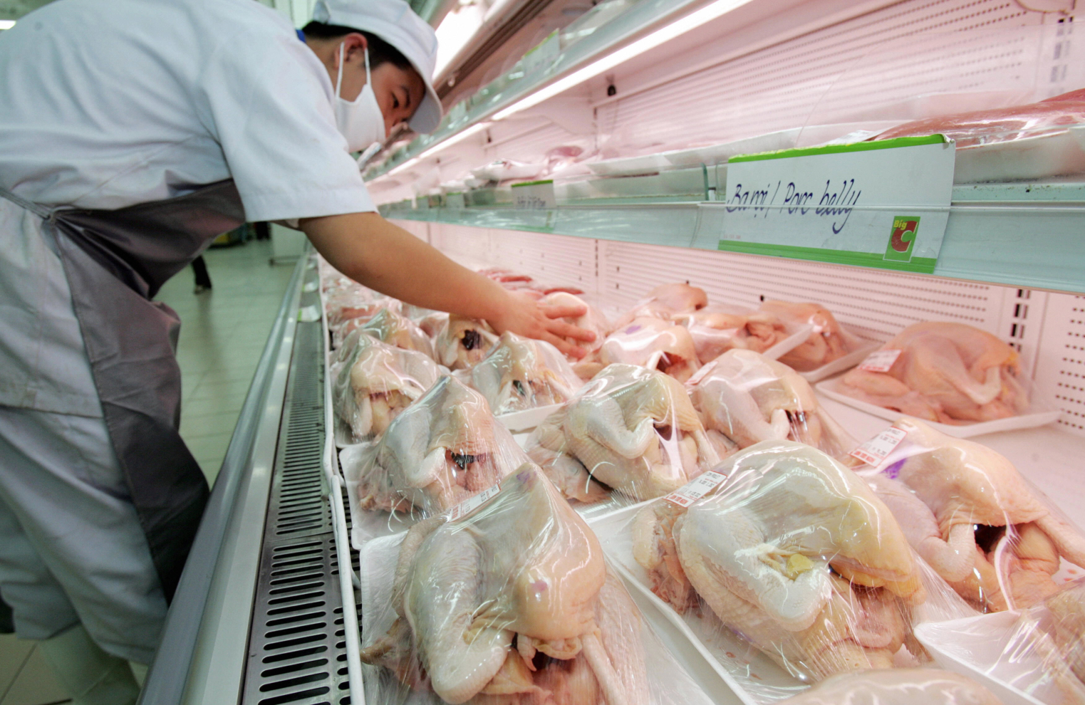 Hanoi, VIET NAM: An employee arranges frozen chicken on sale at a supermarket in Hanoi on 10 March 2006. Vietnam's poultry sector has been ravaged by bird flu, but a lull in infections has left producers divided on whether to slow down or forge ahead and revolutionise the industry. AFP PHOTO/HOANG DINH Nam (Photo credit should read HOANG DINH NAM/AFP via Getty Images)